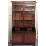 A George IV ebony inlaid mahogany fitted cylinder front bureau bookcase, the upper part with two