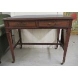 An Edwardian mahogany two drawer writing table, raised on square, tapered legs and casters  30"h