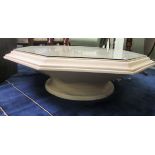 A modern cream wash painted coffee table of octagonal form with antique inspired moulded designs