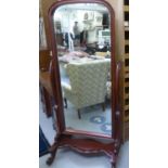 A Victorian style mahogany framed cheval mirror, the bevelled, arched plate pivoting on scolled