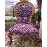 A modern Victorian style mahogany framed salon chair, upholstered in stylised mauve patterned