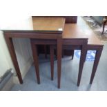 A nesting set of three modern teak occasional table, raised on square, tapered legs largest 20"h