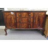 A 1930s mahogany bow front sideboard with a central bank of three drawers, flanked by a pair of