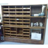 An early 20thC light oak haberdashery cabinet with an arrangement of open, front sliding drawers and