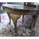 A mid 20thC figured and quartered walnut veneered, tray-top coffee table with a piecrust border,