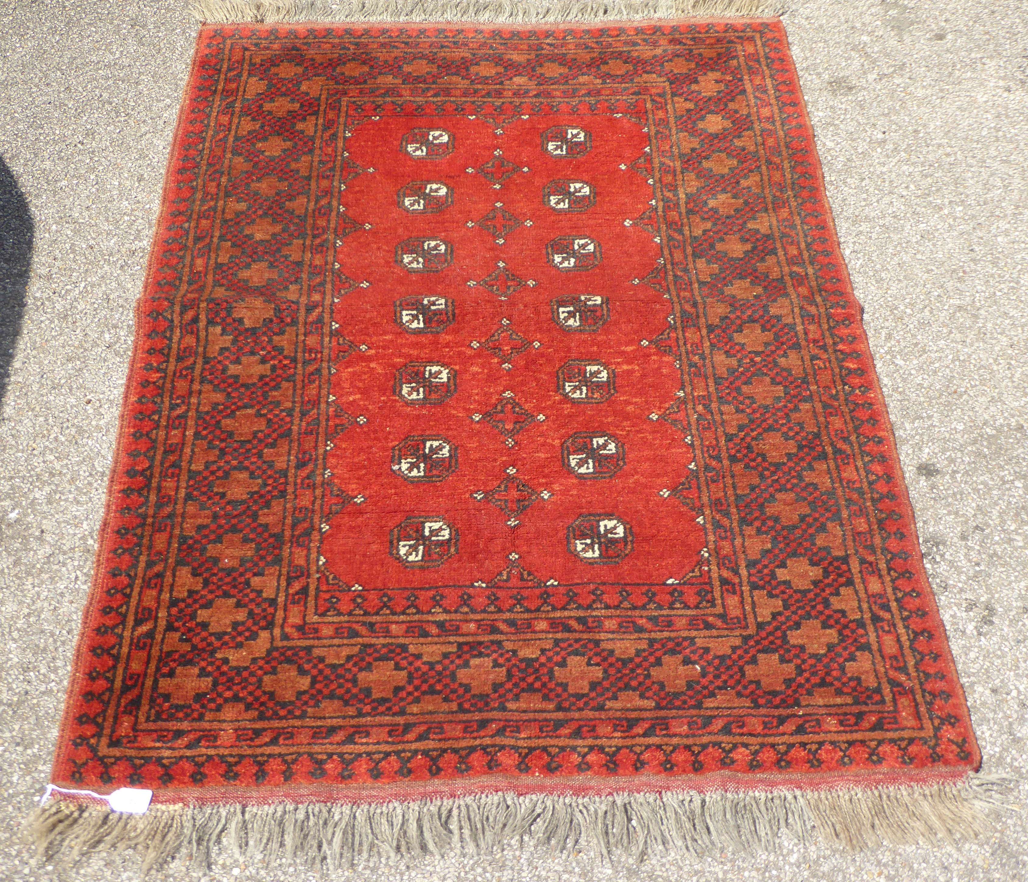 A Bokhara rug with elephant foot pattern motifs, on a terracotta ground  41" x 62"