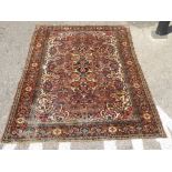 A Persian rug with stylised floral motifs, on a red and blue ground  78" x 60"