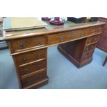 An Edwardian mahogany nine drawer twin pedestal desk, on a plinth and casters  30"h  50"w