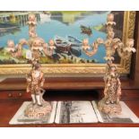 A pair of post 1950s European (possibly Austrian) porcelain triple branch candelabra, decorated with