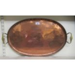 An Arts & Crafts copper oval tray with a ropetwist border and rivetted brass handles  bears a Hugh