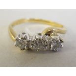 An 18ct gold three stone diamond set crossover ring