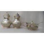 A three piece silver condiments set of oval demi-reeded form  comprising two pepper pots; and a