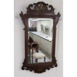 A Chippendale style fretworked mahogany framed mirror with a carved and gilded Ho-Ho bird, cross and