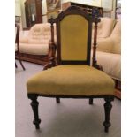 A late Victorian rosewood finished and mahogany framed nursing chair, raised on turned, tapered