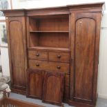 A late Victorian mahogany inverted, breakfront, triple wardrobe, comprising an arrangement of