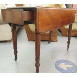 A late Victorian mahogany Pembroke table, raised on ring turned, tapered legs  28"h  36"w