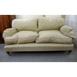 A modern two person settee with a level back and enclosed arms, upholstered in pale old gold