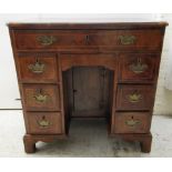 A George III feather inlaid and crossbanded walnut kneehole desk, the concealed, long, shallow