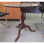 A George III mahogany tip top pedestal table, raised on a turned, bulbous column and tripod base