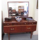 A mid 20thC teak dressing table, surmounted by a mirror, over three frieze drawers, over two long