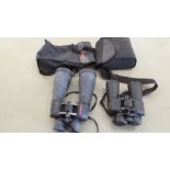 A pair of SkyMaster 15x70 binoculars; and another pair of Nikon Action-ex 10x50 example