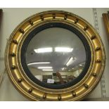 A Regency style convex mirror in a ribbon moulded, gilt frame with applied ball ornament  23"dia