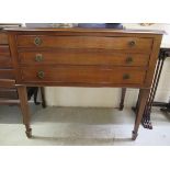 An early 20thC mahogany three drawer serving table, raised on square, tapered legs and spade feet