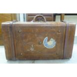 An early 20thC moulded and stitched mid brown hide suitcase with brass studs, a lockable catch and a