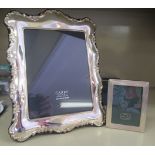 A modern Victorian style glazed silver mounted photograph frame, on a fabric back and easel stand