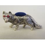 A Sterling silver novelty pin cushion, a prowling fox with ruby set eyes