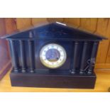 A late Victorian black slate cased mantel clock of architectural form; the 8 day movement faced by