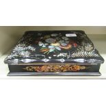 A late Victorian mother-of-pearl inlaid and gilded papier mache writing box with a hinged lid,