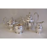 An Edwardian four piece silver tea and coffee set of oval, panelled baluster form with engraved,