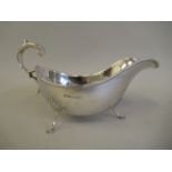 A late Victorian silver sauce boat with an applied wire rim and a double C-scrolled handle, on