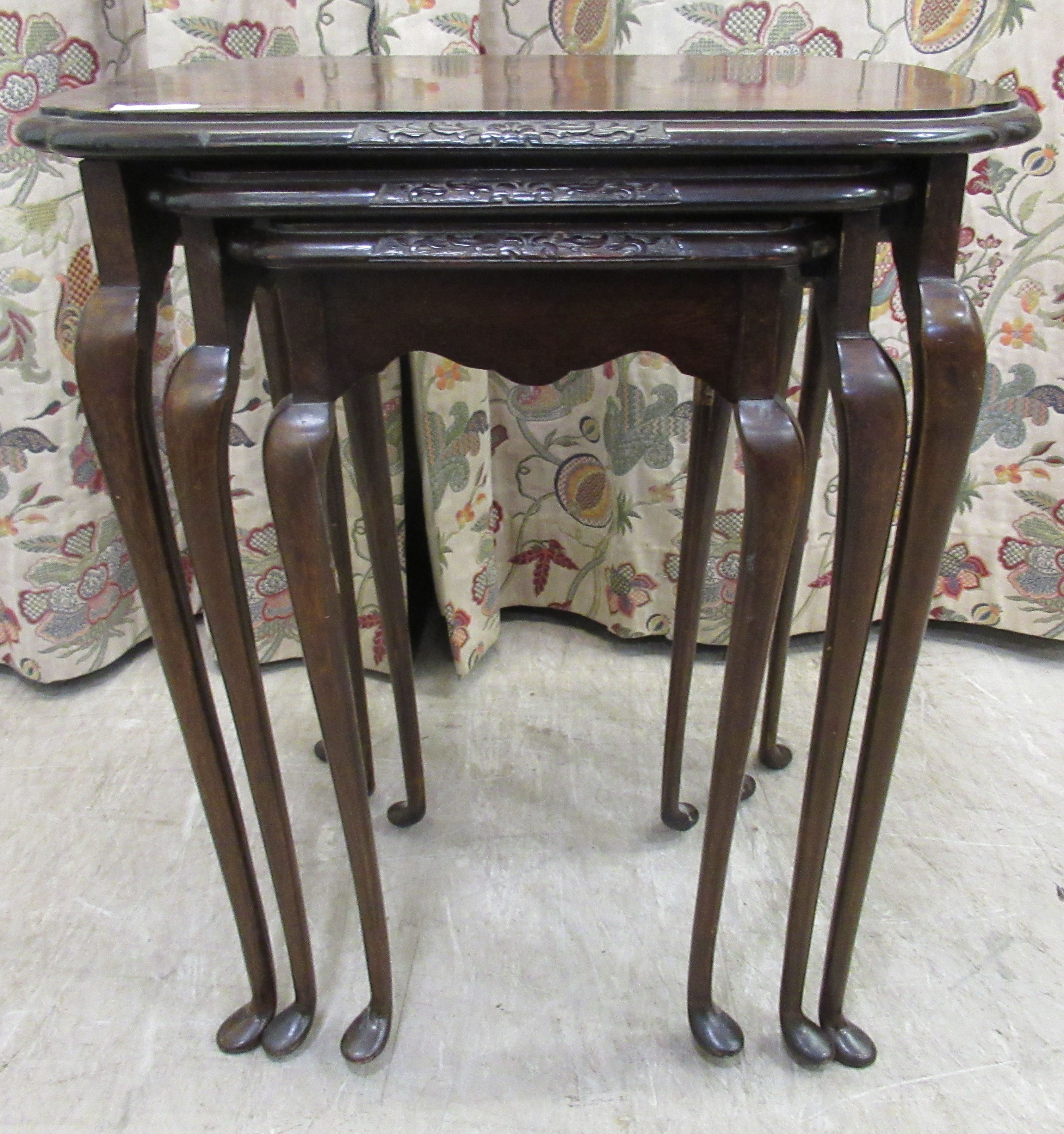 A nesting set of three mid 20thC walnut finished occasional tables, bearing the label of Denby