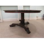 A William IV rosewood centre table, the top with a carved border, raised on a turned pedestal on