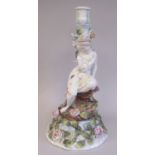 A mid 19thC German porcelain table candlestick with a maiden beside a floral encrusted tree trunk