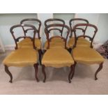 A set of six early Victorian carved rosewood framed balloon and bar back dining chairs, the old gold