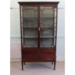 An early 20thC string inlaid mahogany display cabinet with a pair of glazed doors, enclosing four