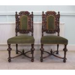 A pair of 19thC profusely carved mahogany framed side chairs with foliate scrolled ornament, the