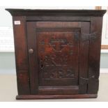 A late 18thC country made, oak hanging corner cupboard, having a moulded cornice, the full height