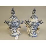 A pair of 19thC Continental porcelain pedestal pot pourri vases and covers, decorated in blue and