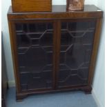 A 1930s mahogany display cabinet with two astragal glazed doors, raised on bracket feet  42"h  35"w