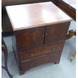 A George III mahogany commode with two doors and two drawers, raised on bracket feet  27"h  23"w