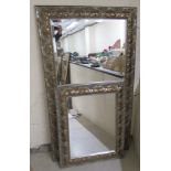 A modern mirror, the bevelled plate set in an Art Nouveau inspired silvered frame  31" x 56"; and