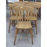 A matched set of five modern stained beech framed kitchen chairs with slatted backs and solid seats,