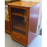 A G-Plan teak stereo cabinet with a glazed door and a drawer, raised on casters  38"h  22"w