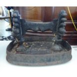 A Victorian cast iron boot scraper, on an integral oval tray base  14"w