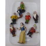 A mid 20thC overpainted cast metal miniature figure, Snow White and the Seven Dwarfs