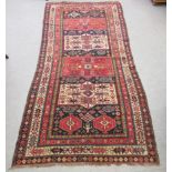 A Persian rug with four stylised medallions, on a floral red and blue ground  98" x 46"
